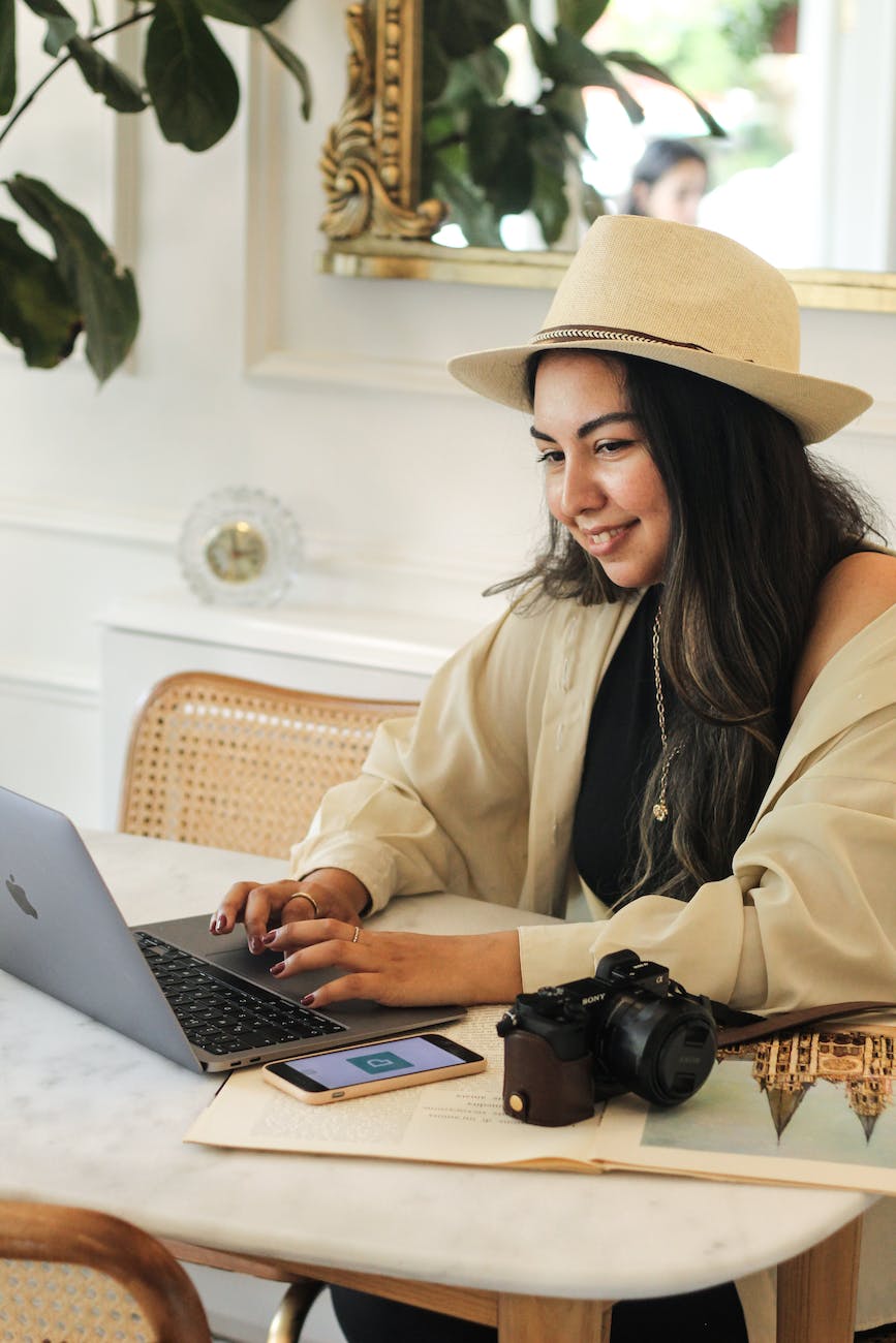 young woman sitting at the table and using a laptop